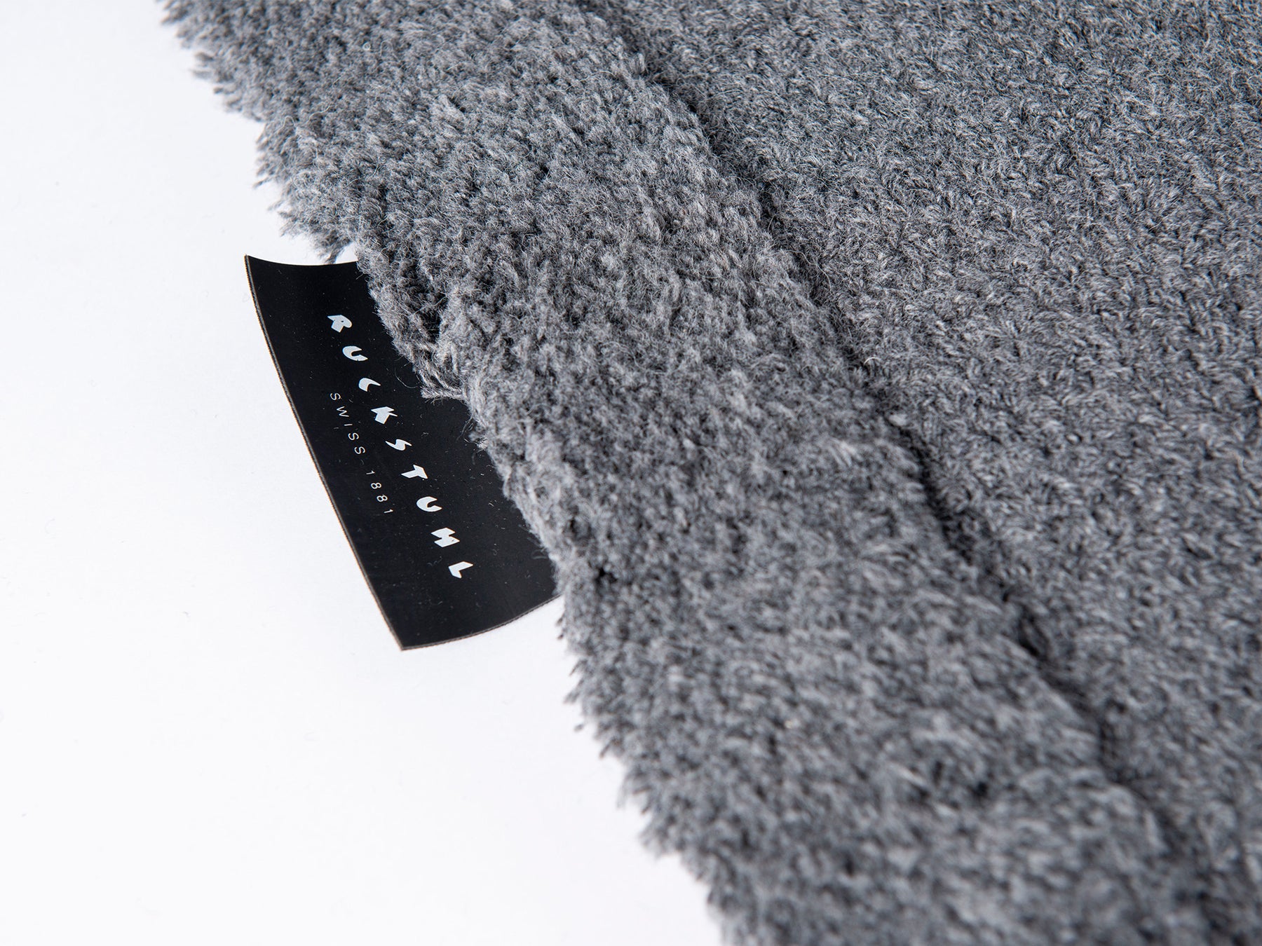 Ruckstuhl Recyclingwollteppich – Forschungsprojekt PHENX von HSLU TEXCIRCLE – Detail des Teppichs mit Produktlabel
